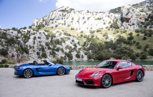 Два спортивных автомобиля Porsche Boxster и Porsche Cayman GTS  у воды 