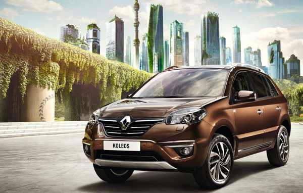 Коричневый автомобиль Рено Колеос на фоне города 