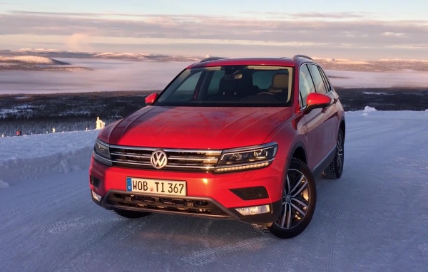 Красный Volkswagen Tiguan 2017 года на заснеженной трассе 