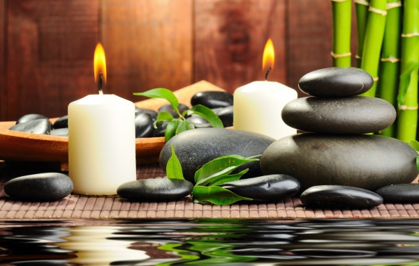 Черные камни дзен с двумя горящими свечами