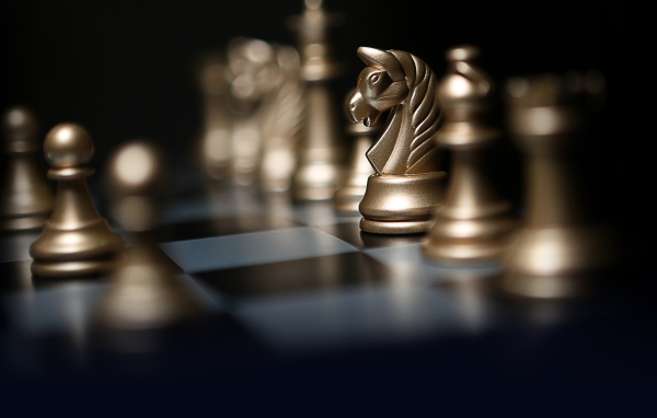 Золотые шахматные фигуры на шахматной доске
