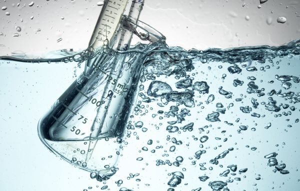 Измерительная чашка в воде с пузырями 