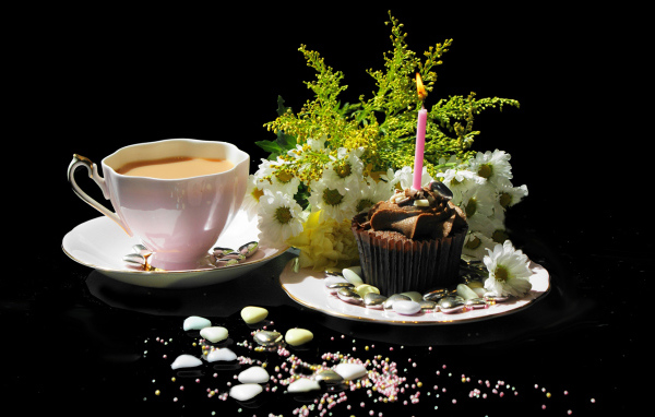 Чашка кофе и праздничный кекс на столе 