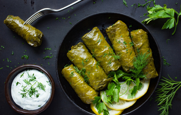 Аппетитная долма с кусочками лимона на столе 