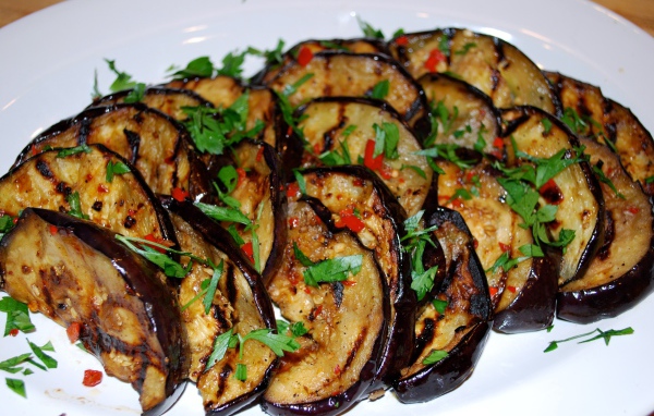 Аппетитные жареные баклажаны на тарелке с зеленью