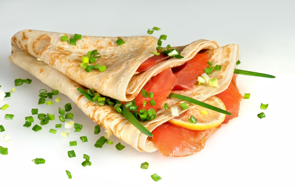 Аппетитный блин с красной рыбой и зеленым луком