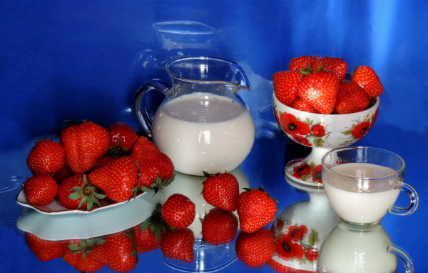 Свежие аппетитные ягоды клубники на столе с молоком