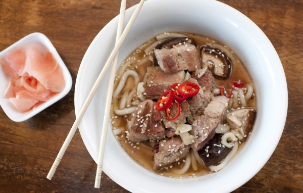 Хайнаньский суп с бараниной, лапшой и кунжутом в белой миске