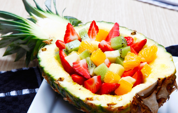 Фруктовый салат из цитрусовых  в тарелке из свежего ананаса 