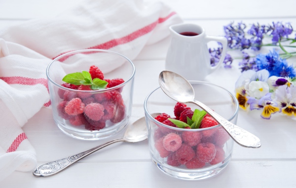 Малина в прозрачный стаканах на завтрак на столе