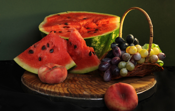 Нарезанный арбуз на столе с виноградом и персиками