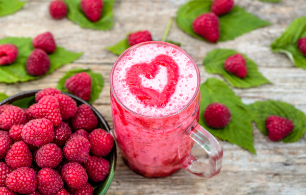 Бокал малинового коктейля со свежими ягодами малины