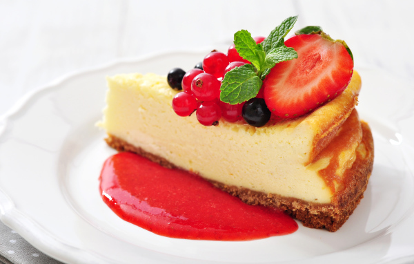 Кусок чизкейка с джемом и ягодами смородины и клубники