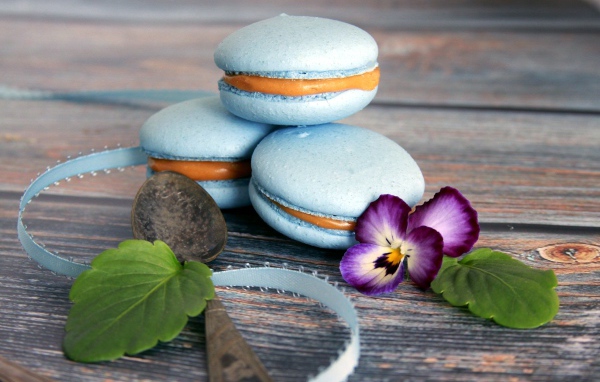 Голубые макаруны на столе с цветком 