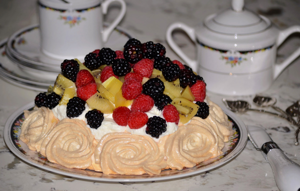 Торт с безе и свежими ягодами на столе 