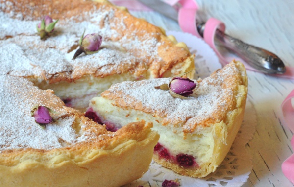 Пирог с суфле и малиной посыпанный сахарной пудрой и цветами