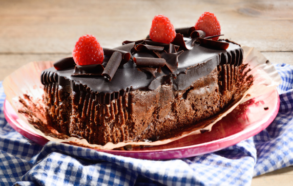 Шоколадное пирожное со свежей малиной на тарелке