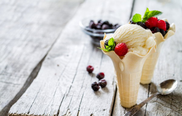 Сливочное мороженое в вафельном стаканчике с ягодами