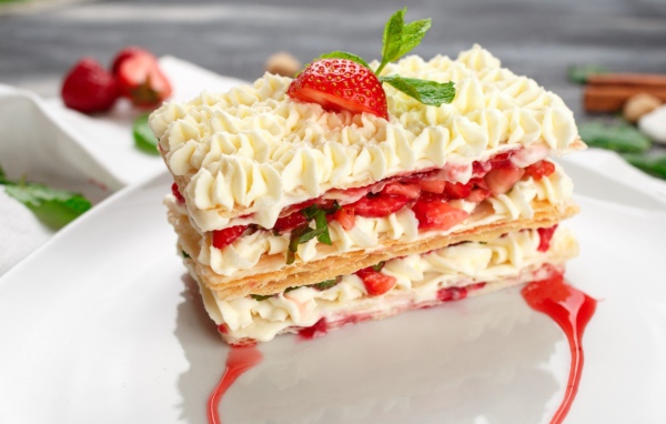 Вкусное сладкое пирожное с кремом и клубникой