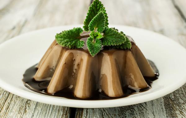 Десерт из желе на белой тарелке с шоколадом