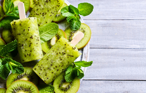 Мороженое с киви и листиками мяты на деревянном столе