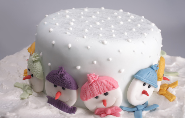 Новогодний торт украшен снеговиками из сахара