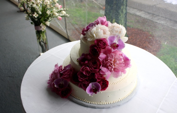 Большой свадебный торт украшен живыми цветами