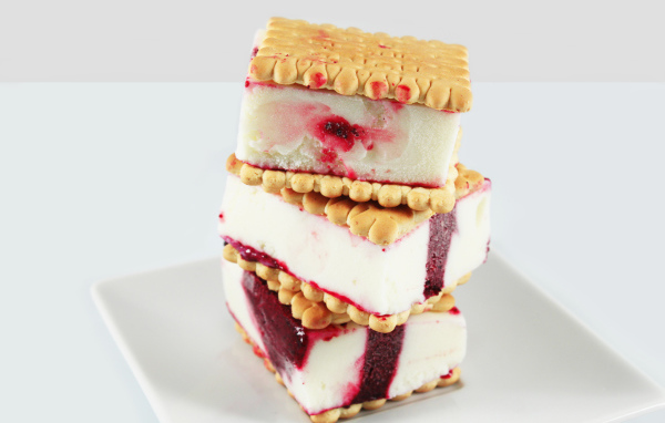 Три кусочка мороженого с печеньем на сером фоне