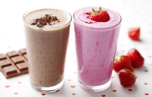Шоколадное и клубничное смузи в стаканах на столе