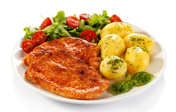 Аппетитные отбивные с вареным картофелем и салатом на белой тарелке