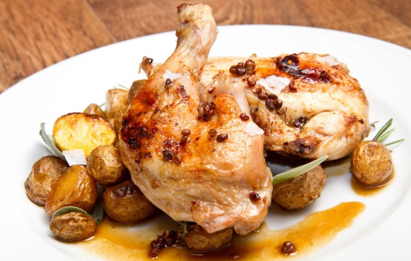 Жареные окорочка с картофелем на белой тарелке