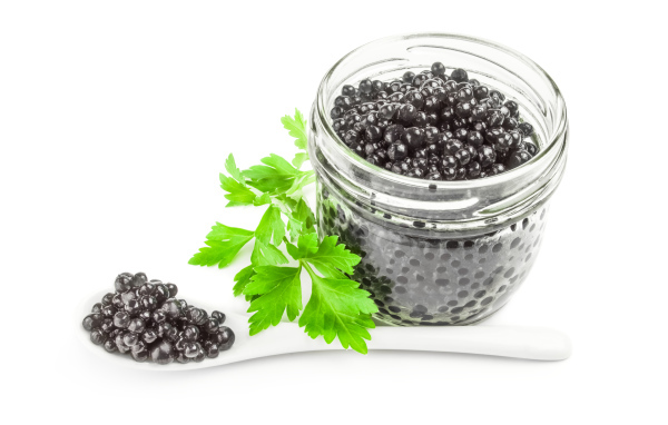 Банка черной икры с ложкой на белом фоне