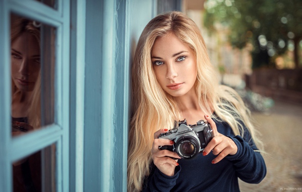 Красивая девушка блондинка с фотоаппаратом 