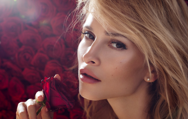 Красивая девушка блондинка с красной розой в руке
