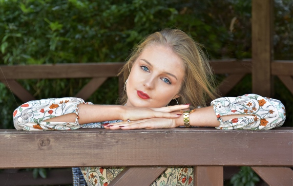 Красивая голубоглазая девушка с часами на руке