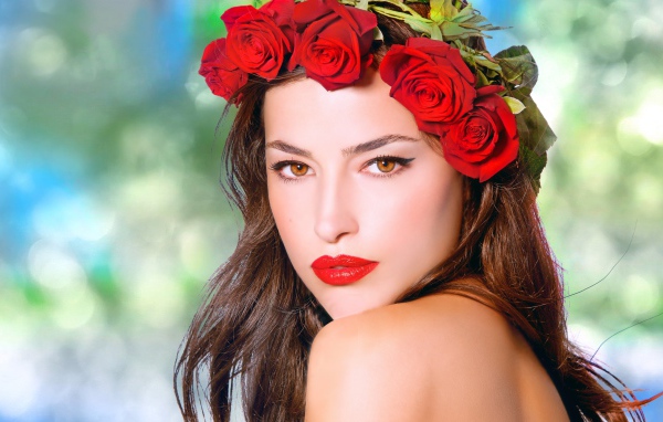 Красивая кареглазая девушка с венком из красных роз 