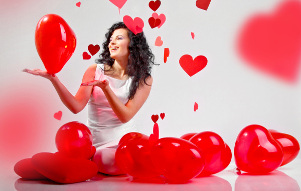 Красивая девушка брюнетка с воздушными шарами в форме сердца