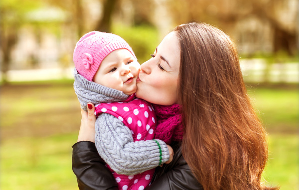 Красивая девушка держит в руках маленького ребенка