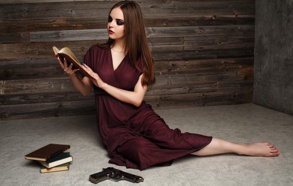 Красивая девушка в бордовом платье с книгами