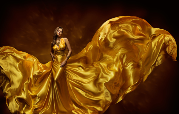 Красивая девушка шатенка в красивом платье золотого цвета