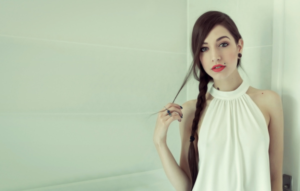 Красивая девушка с красными губами заплетенными в косу волосами