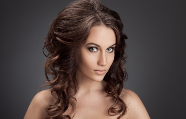 Красивая девушка с волнистыми волосами фото на сером фоне