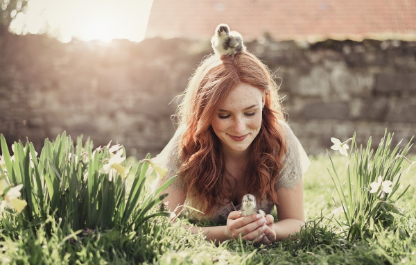 Красивая рыжеволосая девушка с маленькими цыплятами  