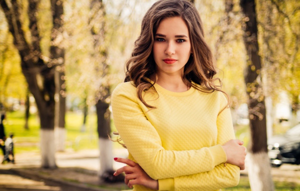 Красивая молодая голубоглазая девушка в желтом свитере