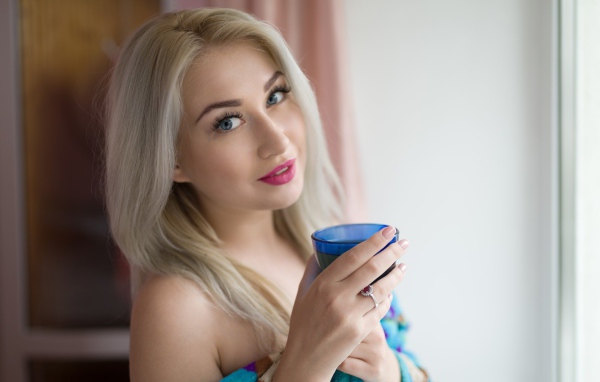 Блондинка с розовыми губами и стаканом в руках 