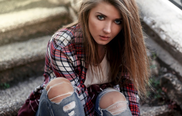 Голубоглазая девушка брюнетка в модных джинсах 