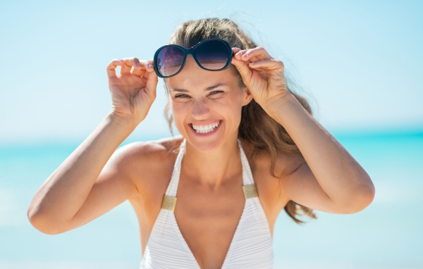 Улыбающаяся девушка с очками на голове