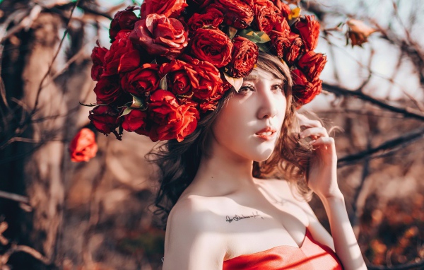 Молодая девушка азиатка с красными цветами на голове