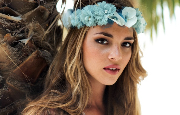 Молодая девушка модель с венком из голубых цветов на голове 