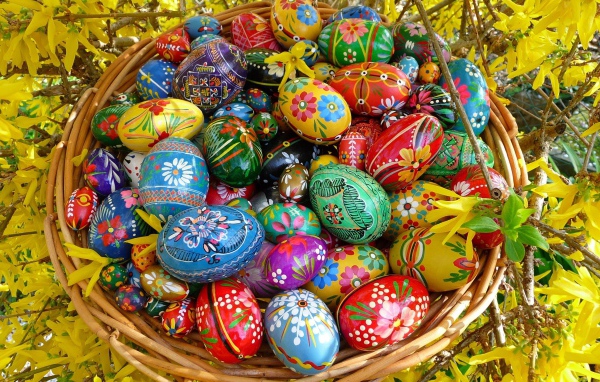 Яркие расписные пасхальные яйца в корзине 